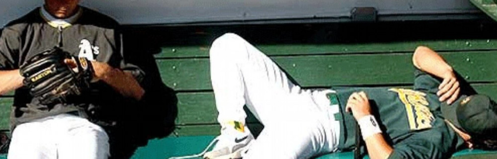 Baseball player laying down on the bench