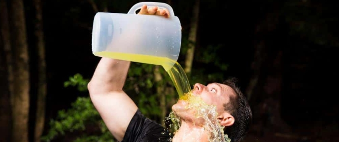 Man pouring orange juice on his face