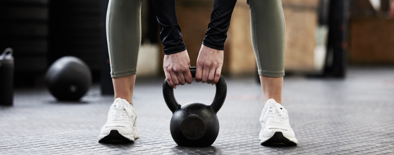 Lady lifting kettlebell in gym